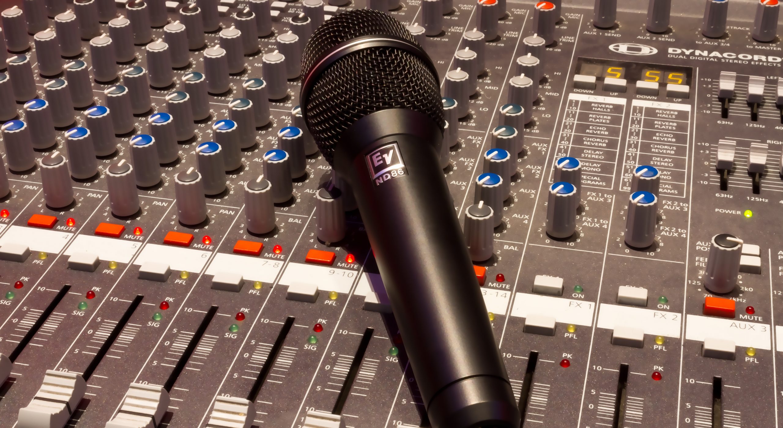 Microphone resting on an audio mixing desk